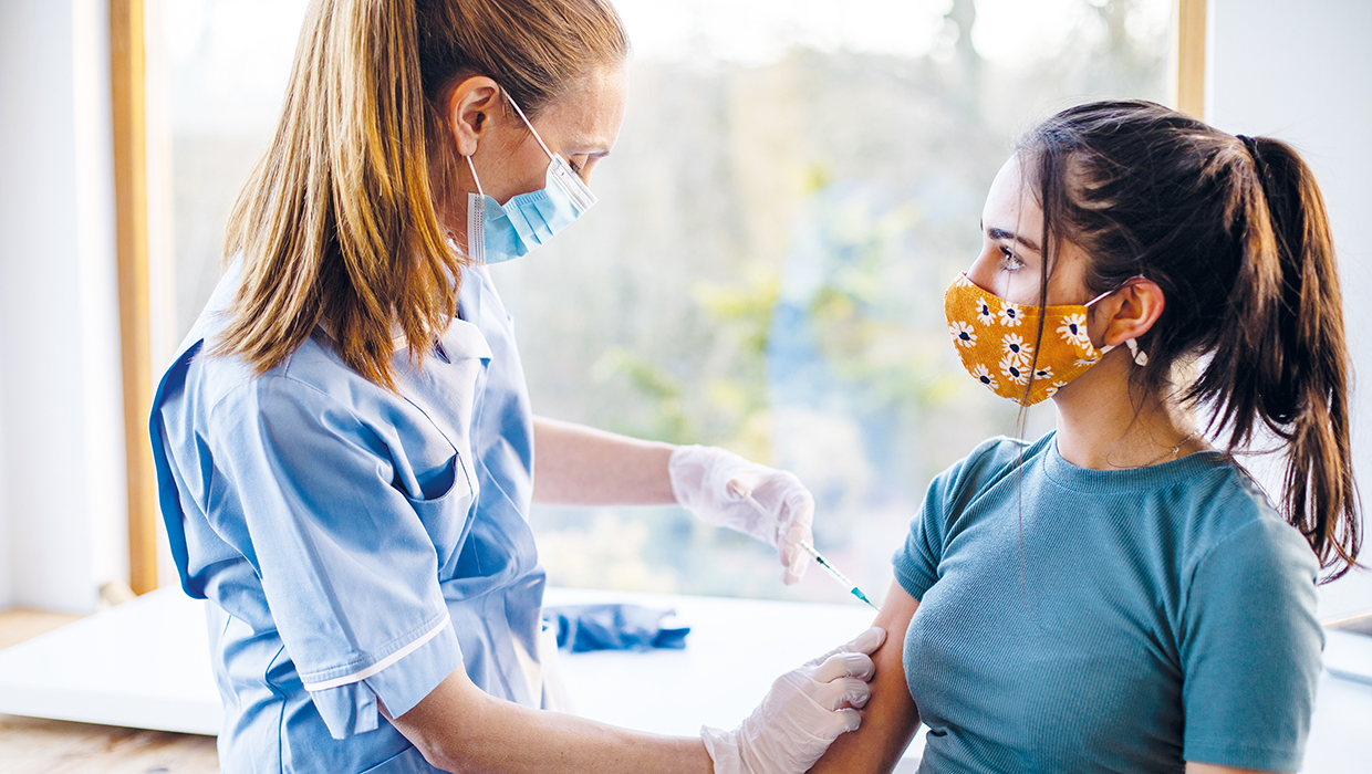 Photo of a woman receiving her Covid-19 vaccination from a nurse